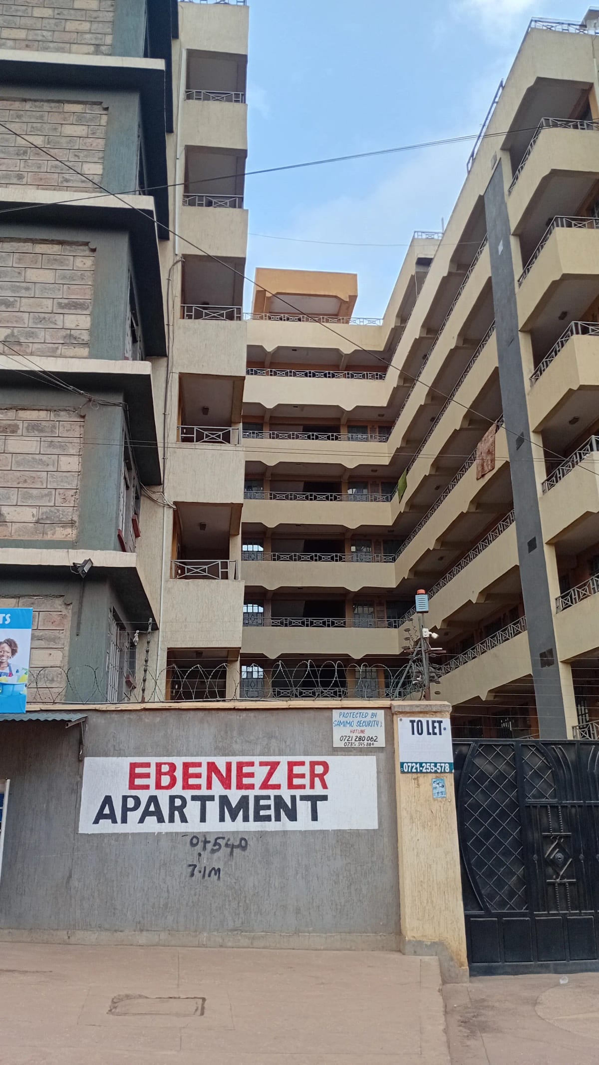 Multi-story residential building facade with balconies and entrance