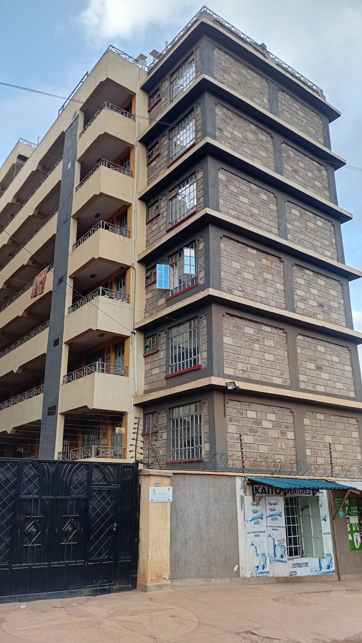 Multi-story residential building facade with balconies and ground-floor shops