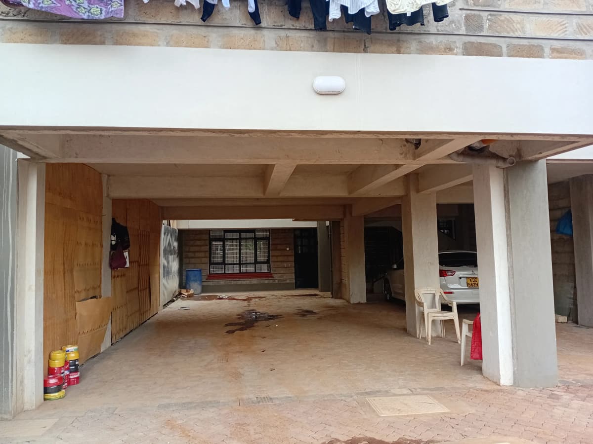 Covered parking bay with concrete floor and support columns