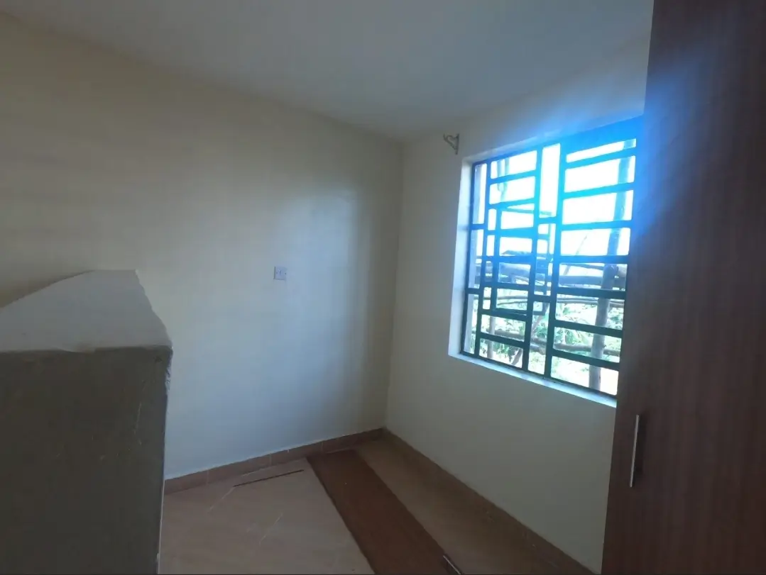 Unfurnished bedroom with barred window and natural light