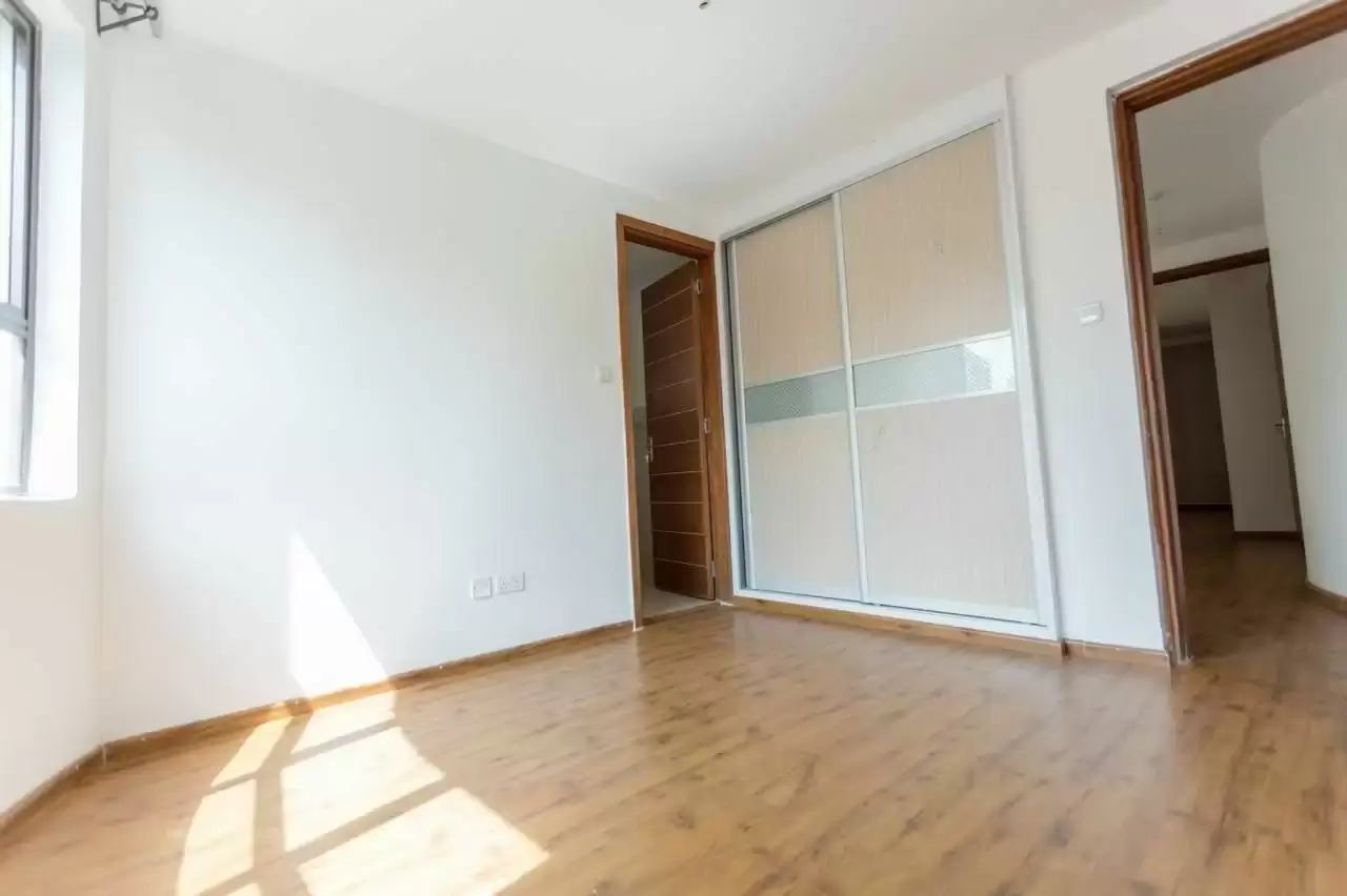 Spacious bedroom with built-in wardrobe and wooden flooring