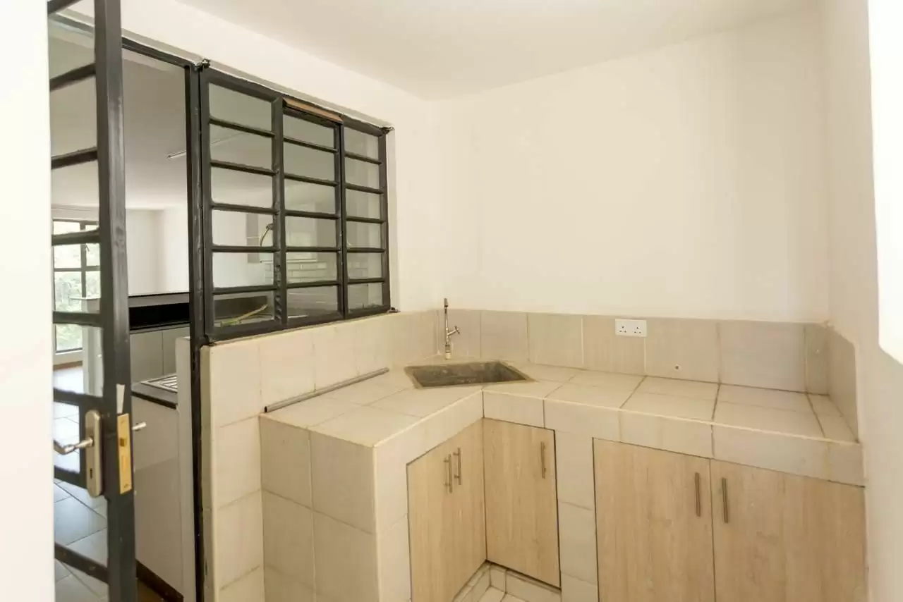 Compact kitchen with cream cabinetry and stainless sink.