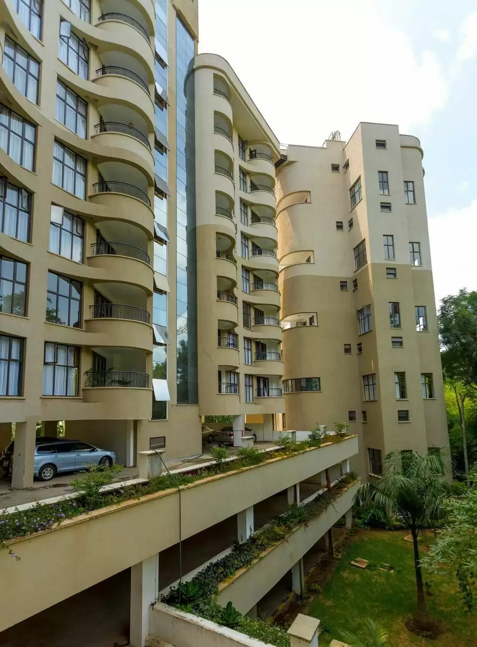 Multi-story residential building with curved balconies and landscaped grounds
