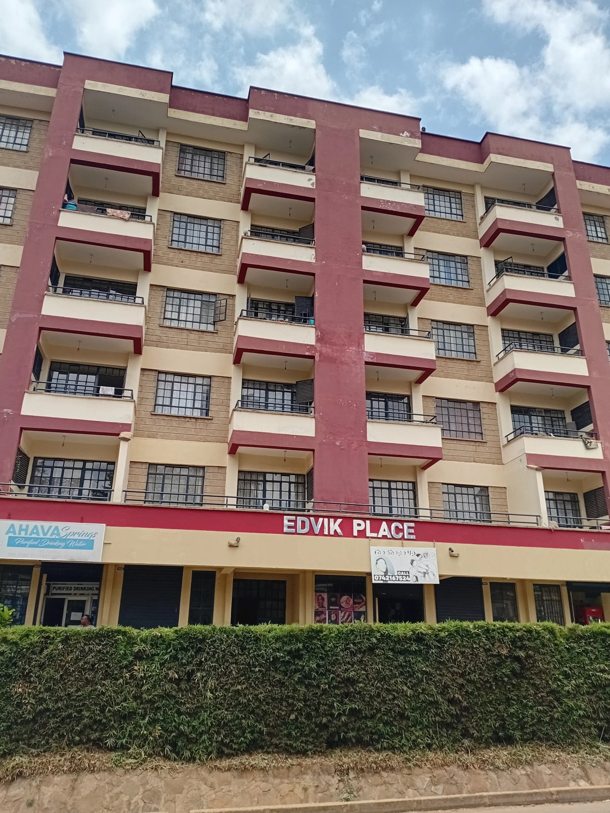 Multi-story residential building with red and cream facade
