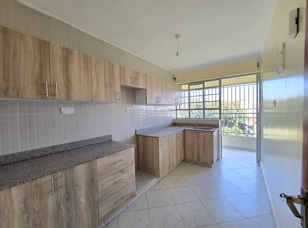 Modern kitchen with wooden cabinets and balcony access