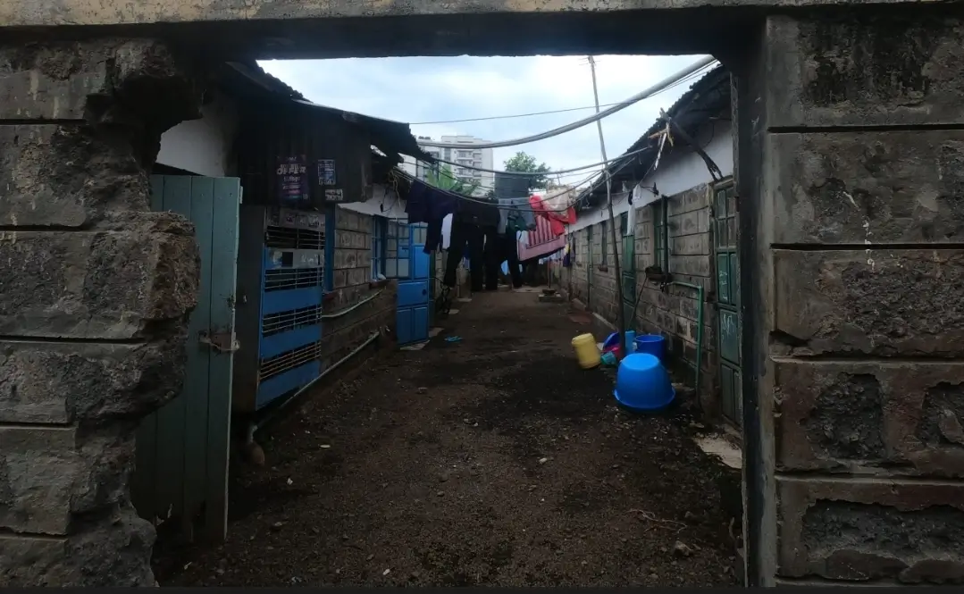 Compound entrance with narrow alleyway and residential structures