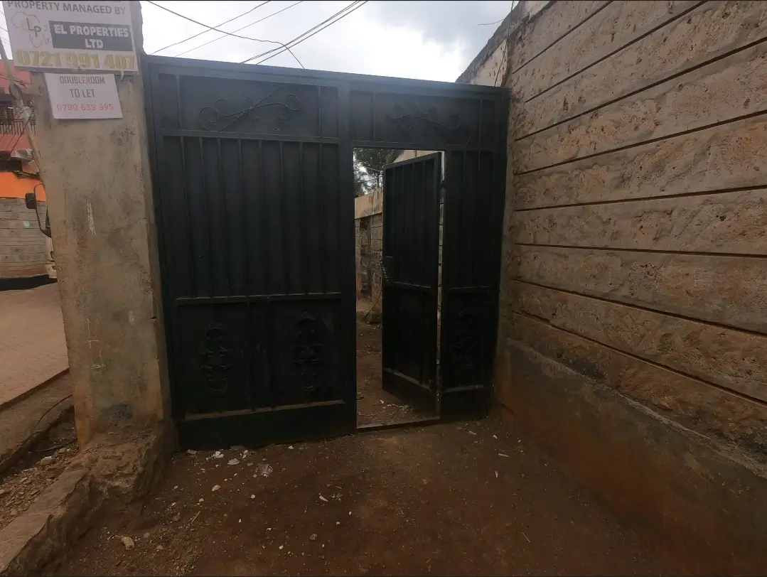 Covered parking bay with metal gates and concrete floor
