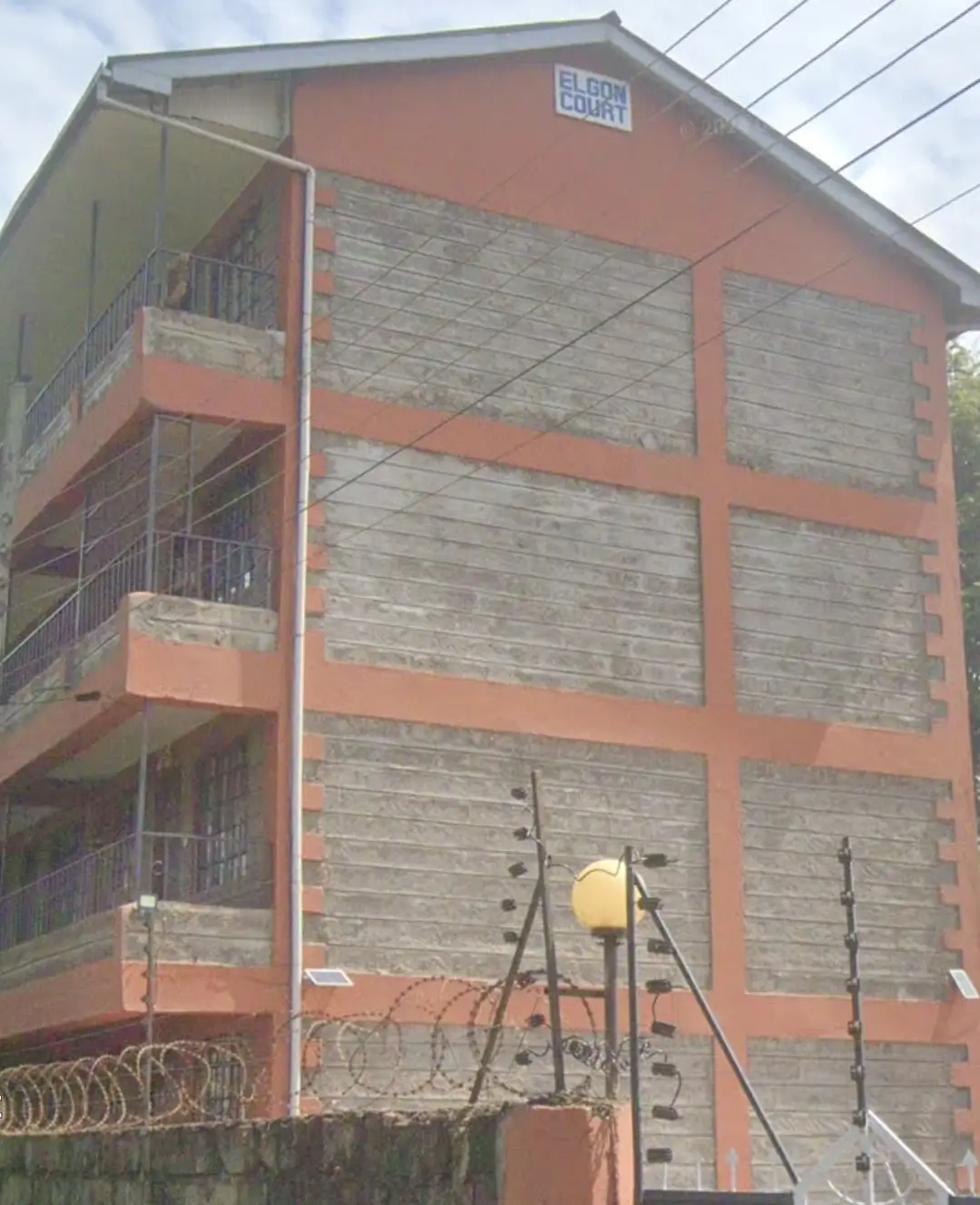 Multi-story residential building with red frame and brick facade