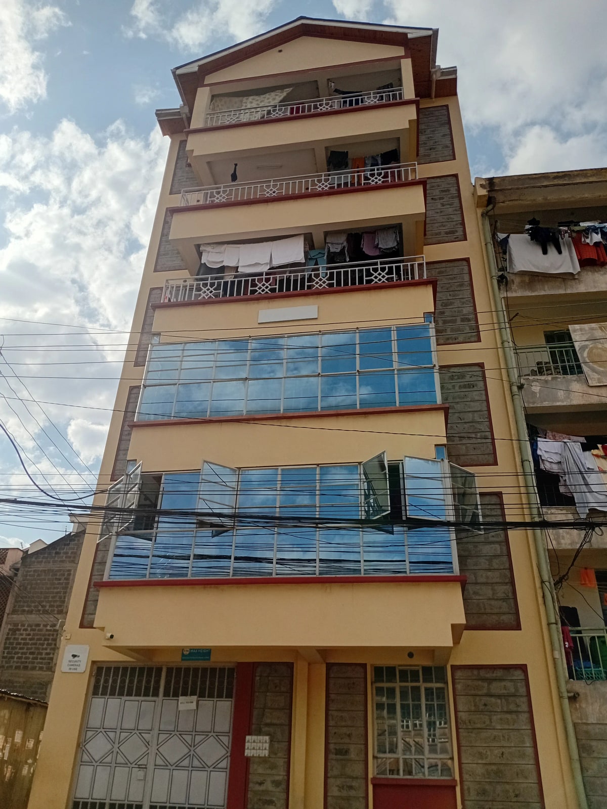 Multi-story residential building facade with balconies and blue windows