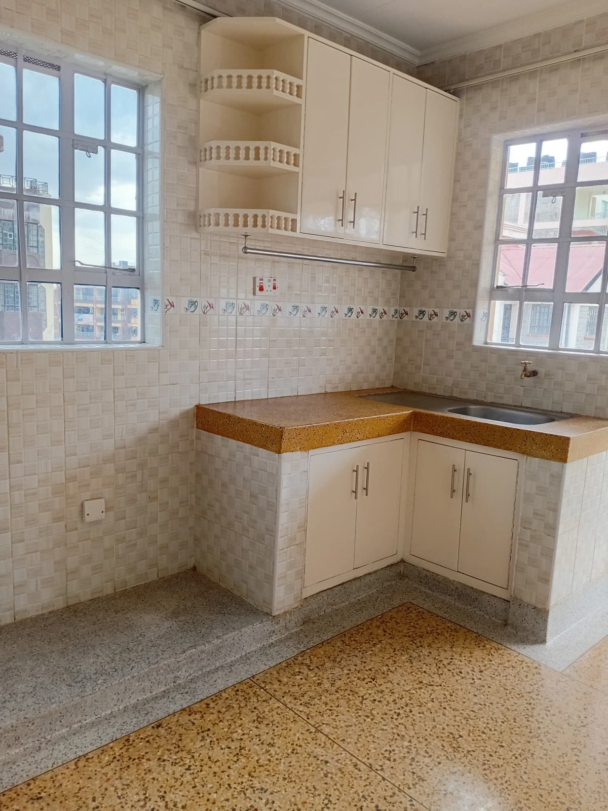 Compact kitchen with cream cabinetry and wooden countertops