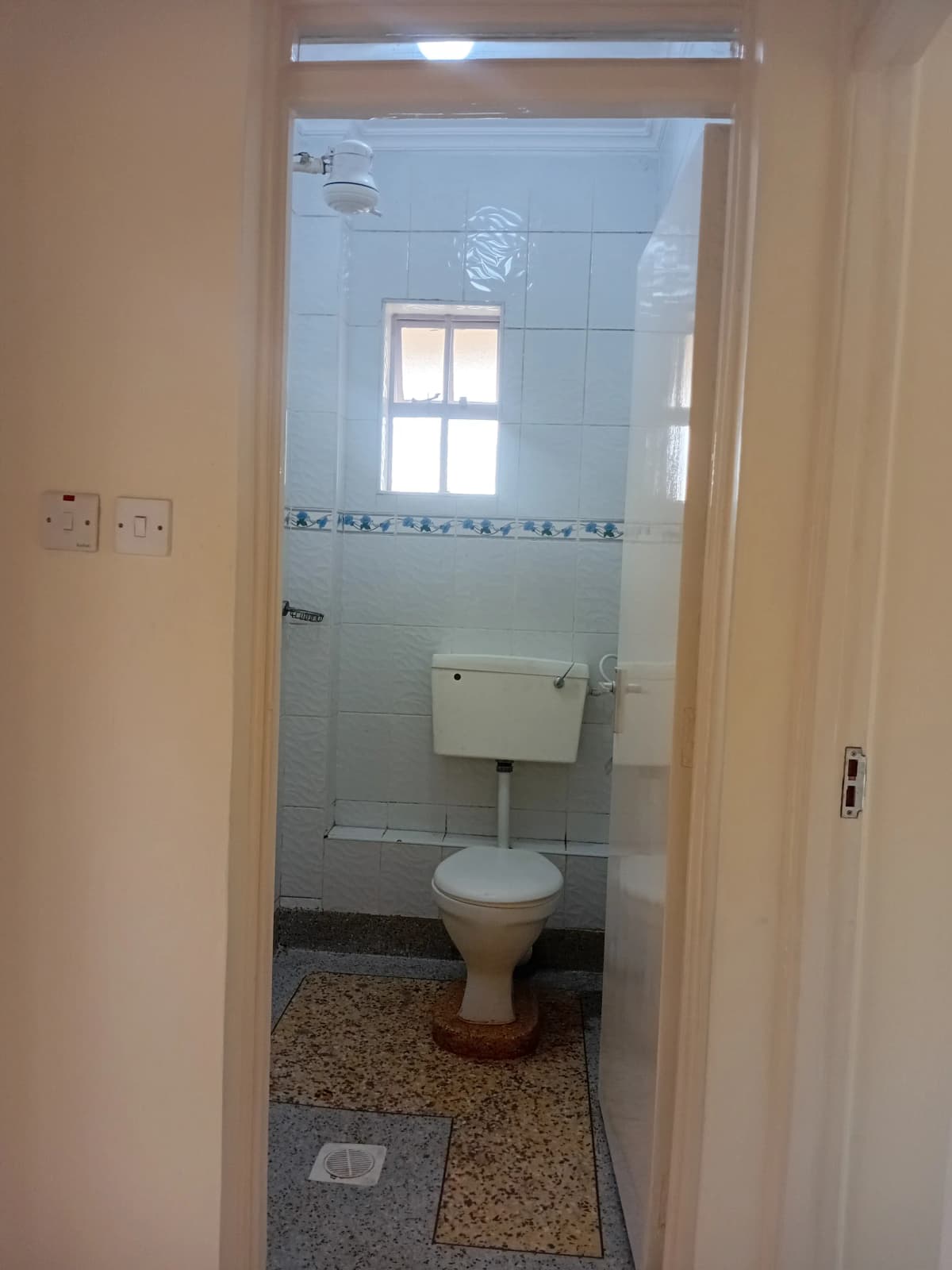 Compact bathroom with toilet, sink, and shower enclosure