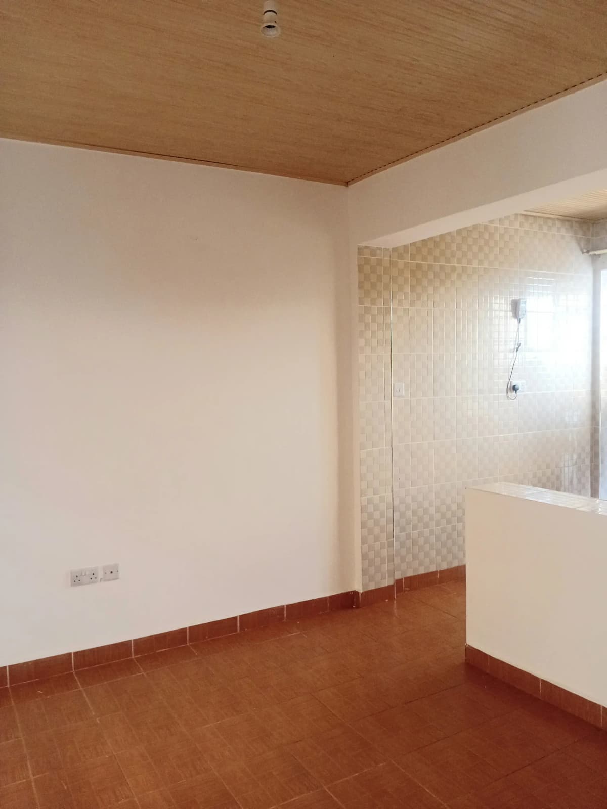 Empty bedroom with terracotta floor and wooden ceiling