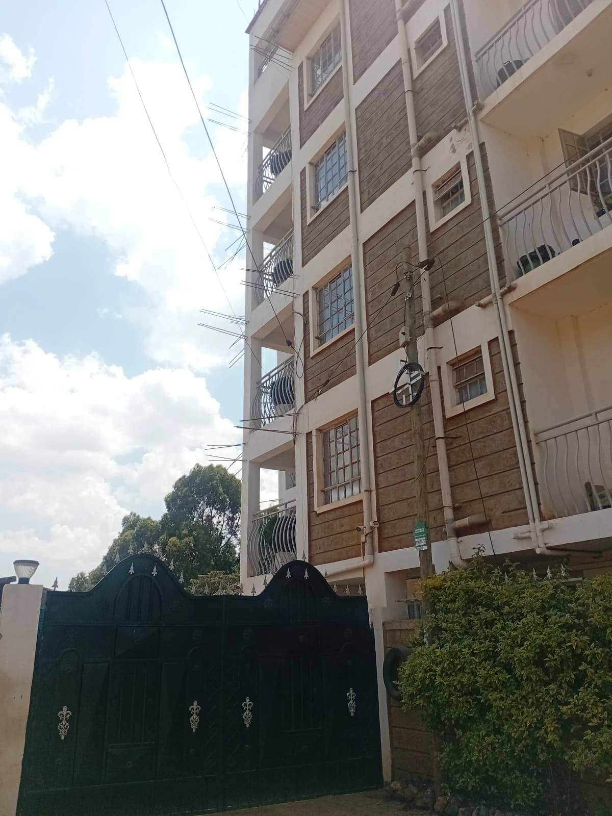 Multi-story residential building facade with balconies and gate