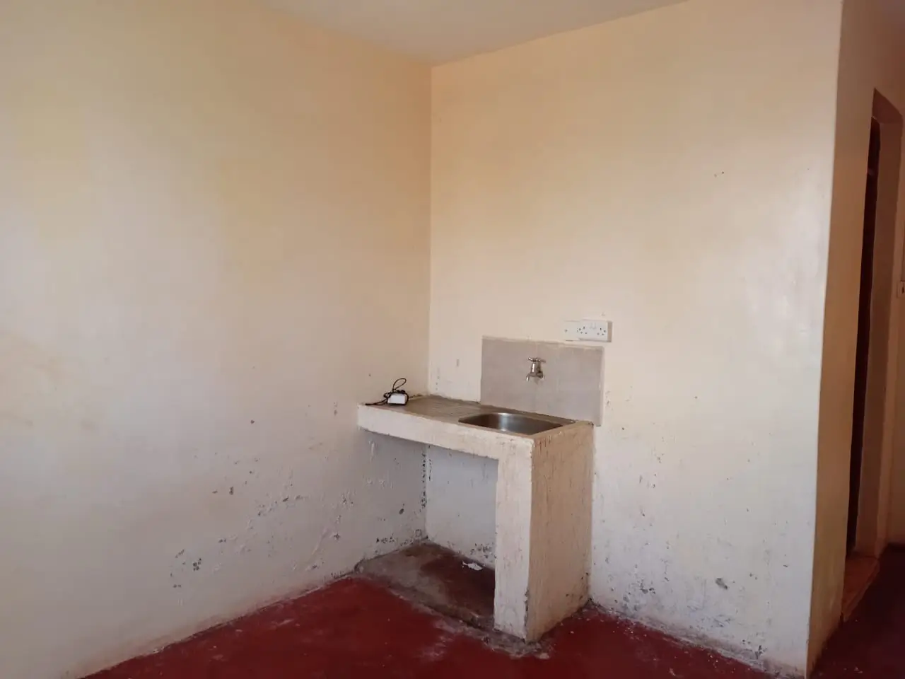 Minimal kitchenette with basic sink and stove setup