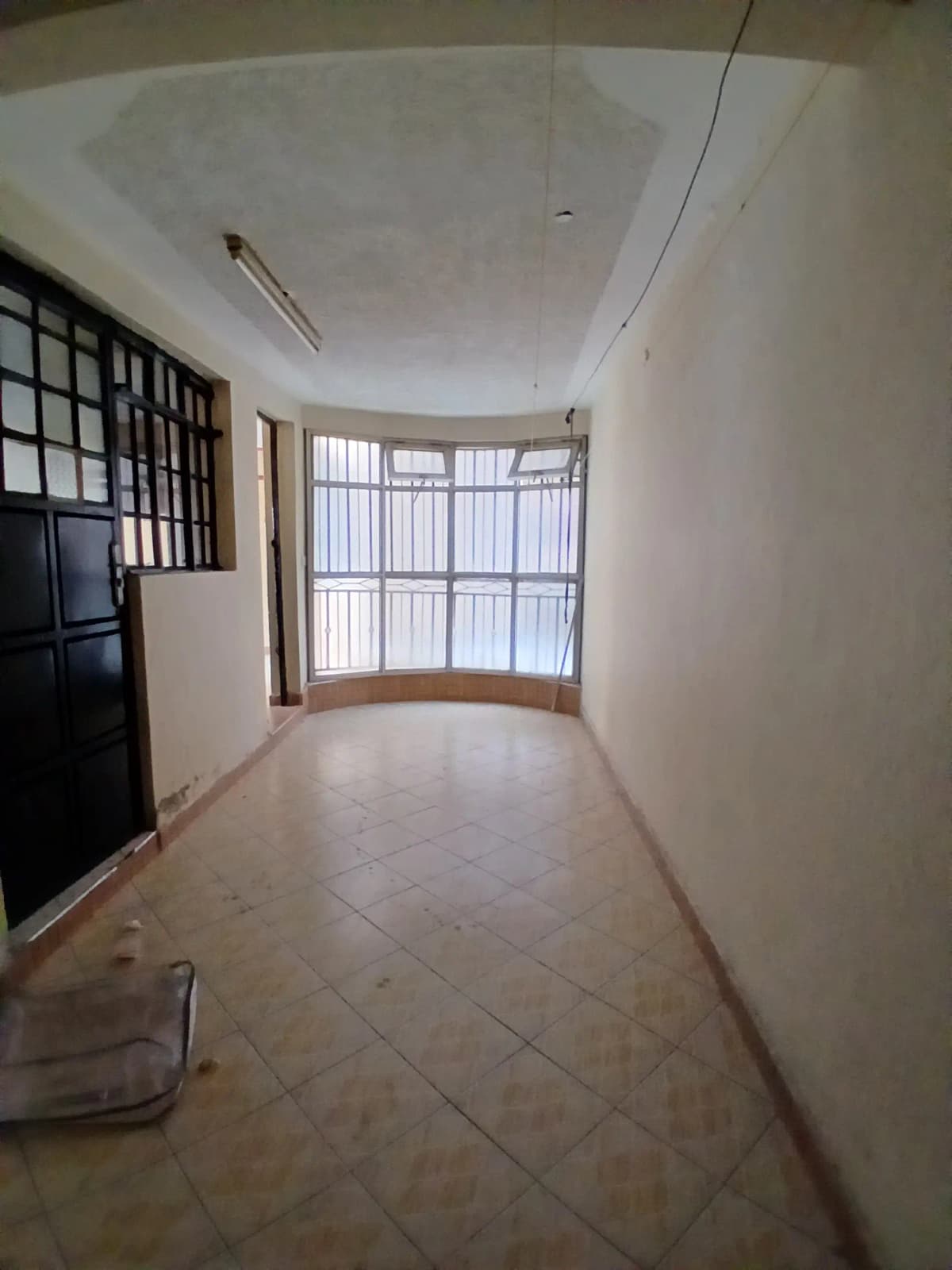 Curved balcony with large windows and tiled flooring