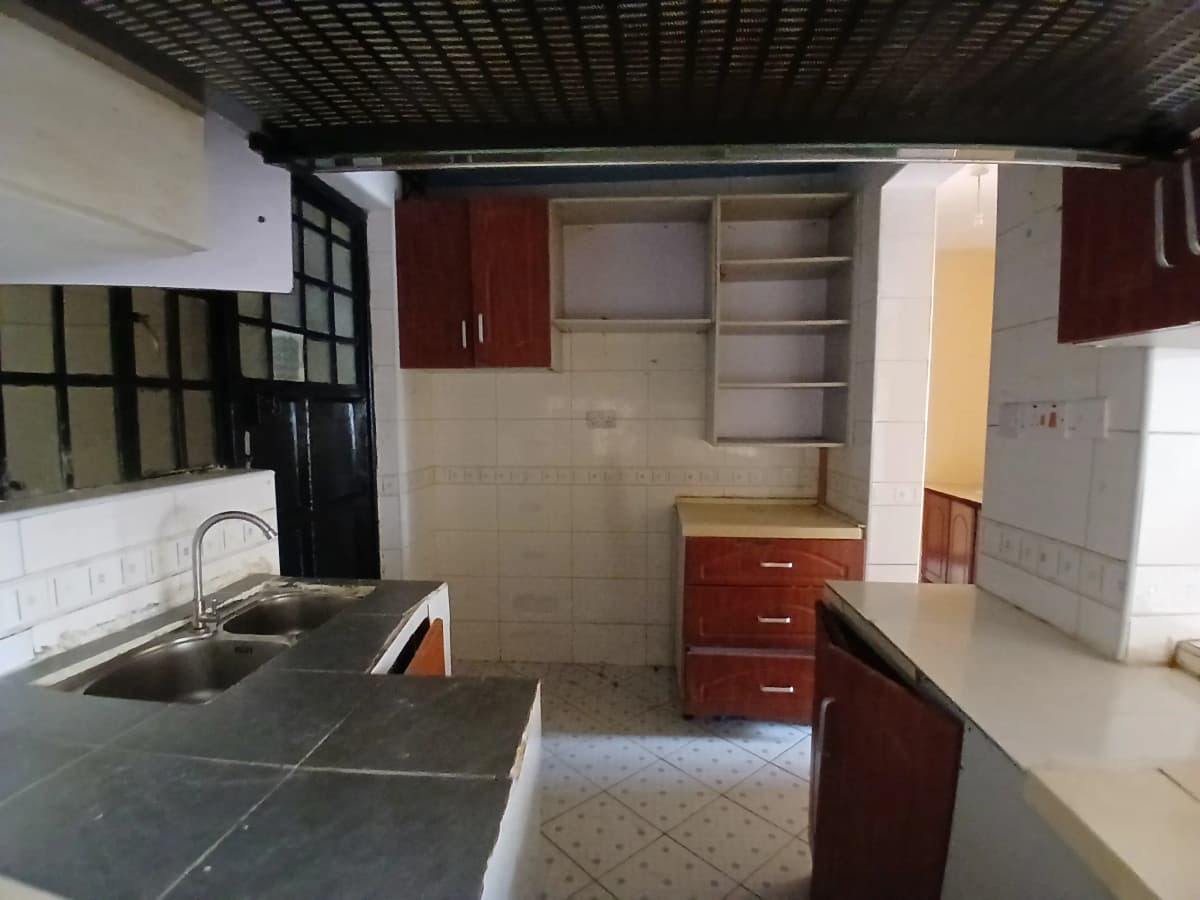 Spacious kitchen with dark red cabinetry and dark countertops