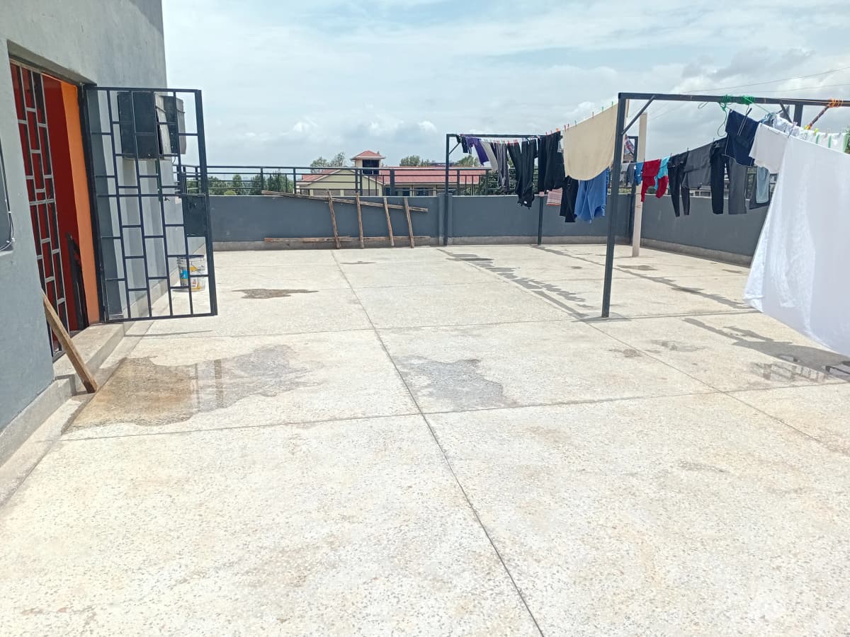 Rooftop laundry drying area with clotheslines and concrete floor