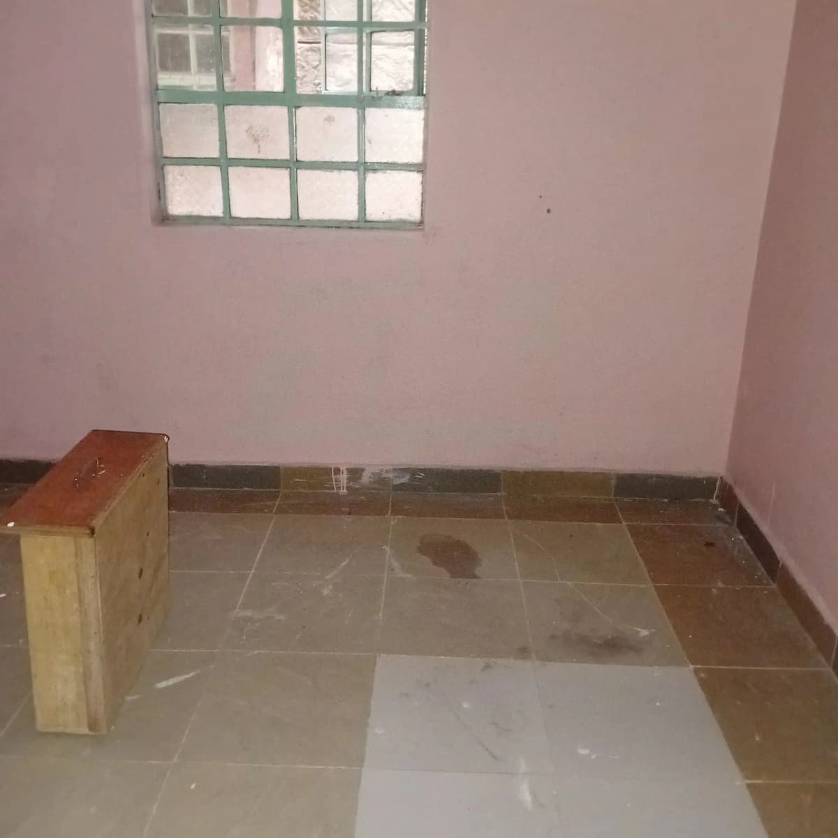 Empty bedroom with pink walls and barred window
