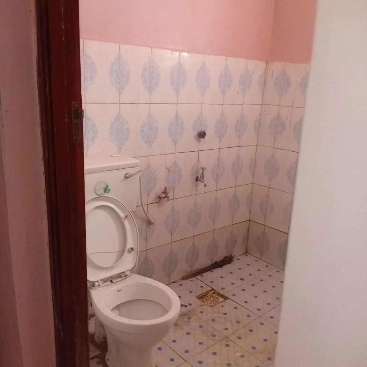 Simple bathroom with white ceramic toilet and patterned wall tiles