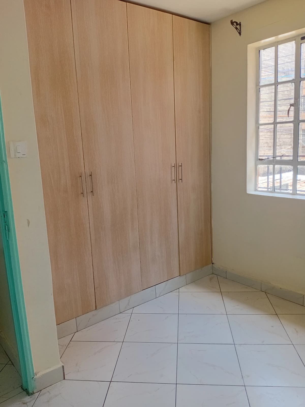 Bedroom with built-in wooden wardrobe and tiled flooring