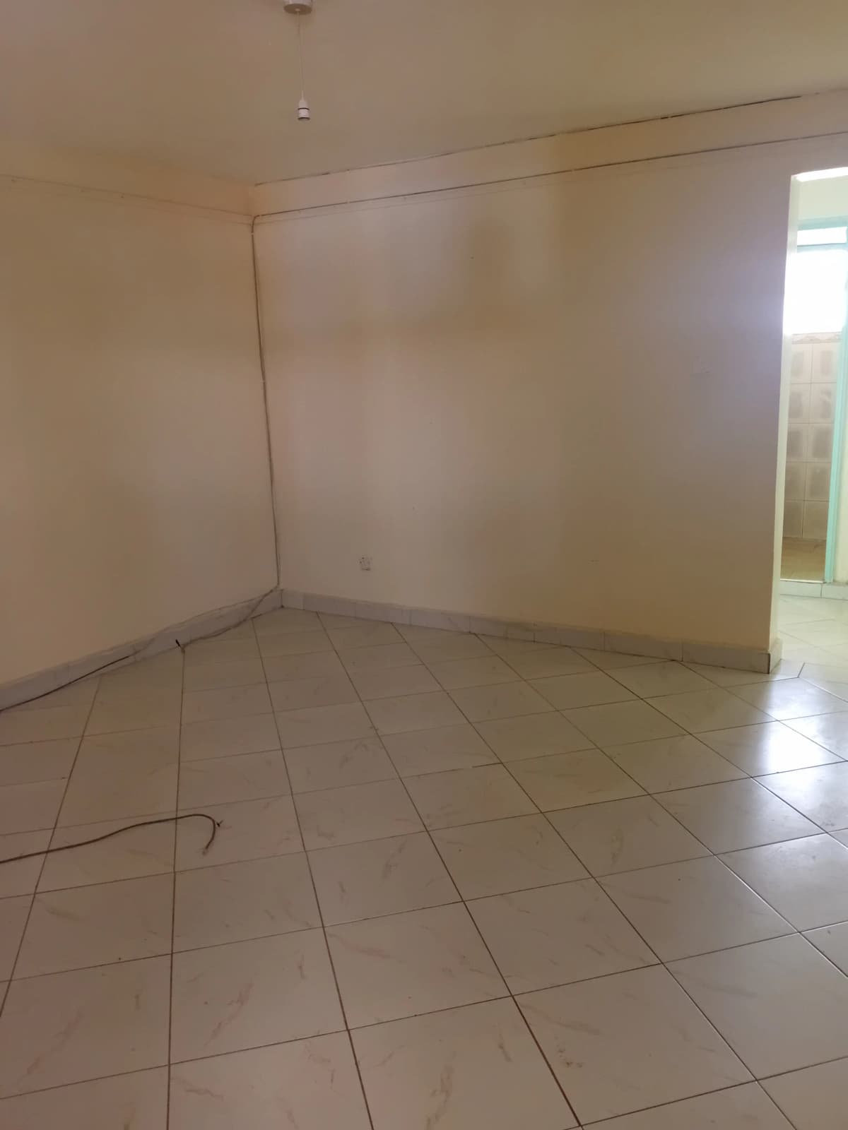 Empty room with tiled floor and natural light from window