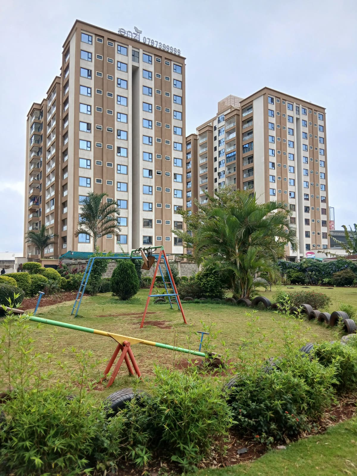Multi-story residential complex with manicured grounds and playground