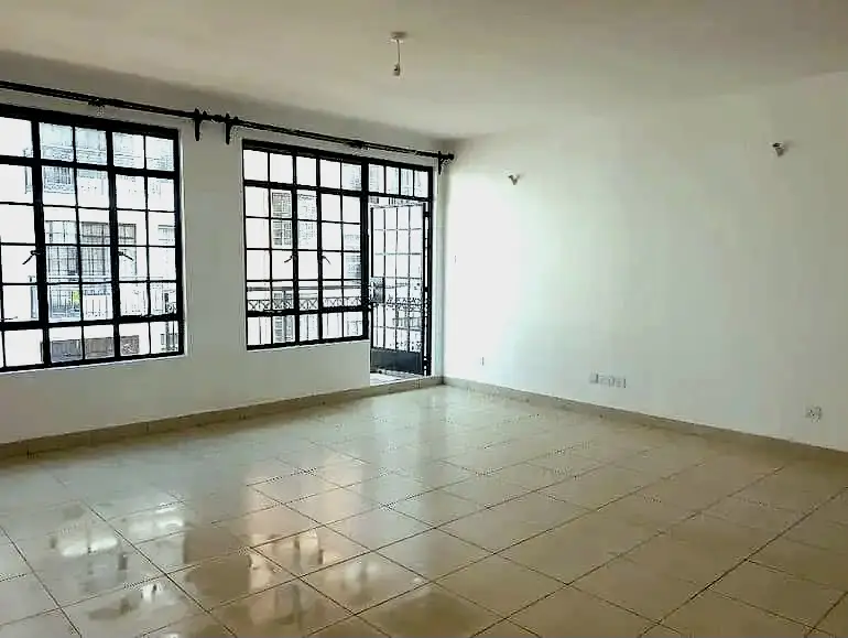 Spacious living room with large gridded windows and tiled flooring