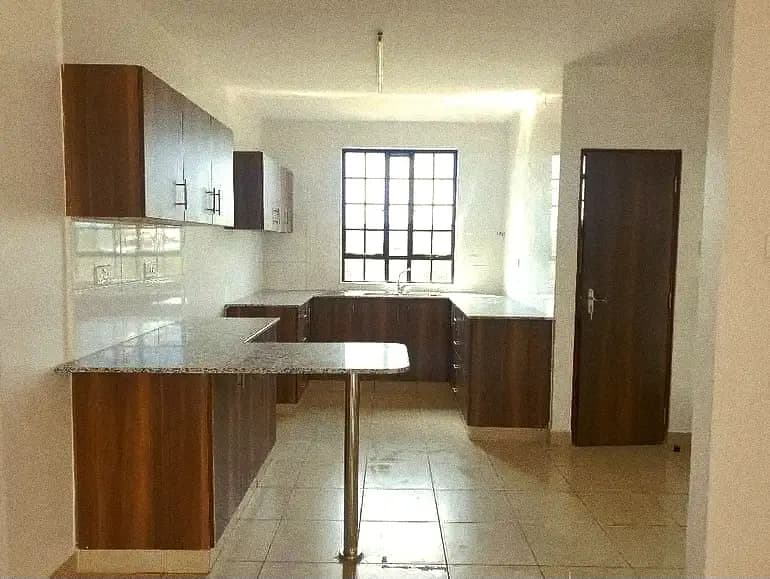 Open-plan kitchen with wooden cabinetry and dining counter