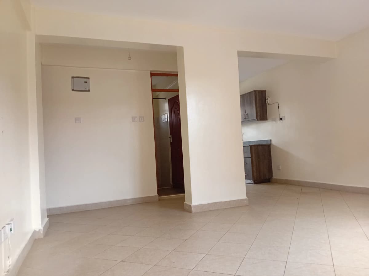 Spacious empty living room with tiled flooring and partition wall