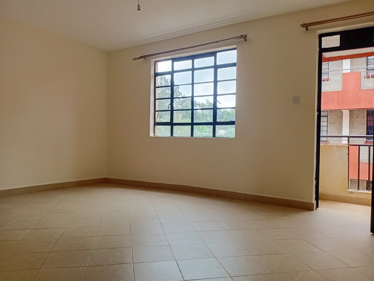 Spacious empty living room with large window and tiled floor