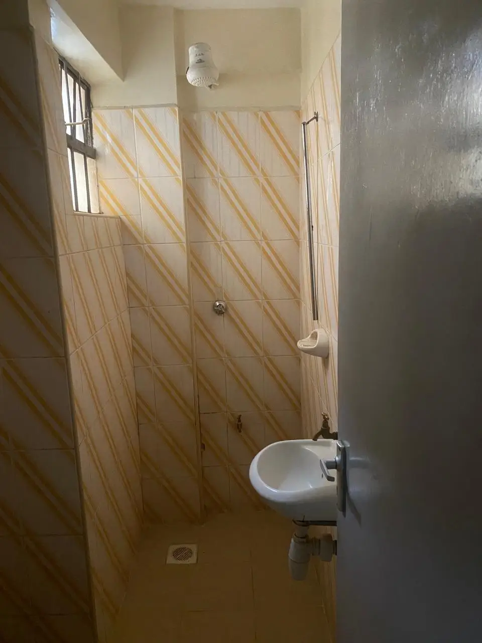 Compact bathroom with wall-mounted sink and diagonal wood paneling