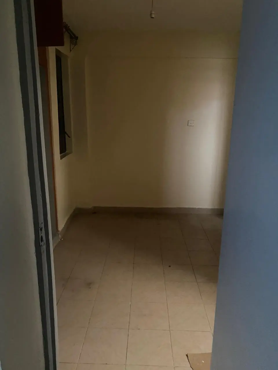 Empty corridor with tiled flooring and neutral walls