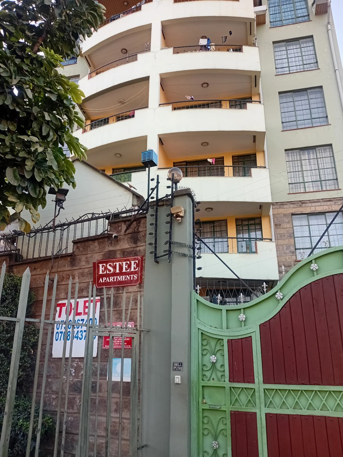 Multi-story residential building facade with curved balconies and gates