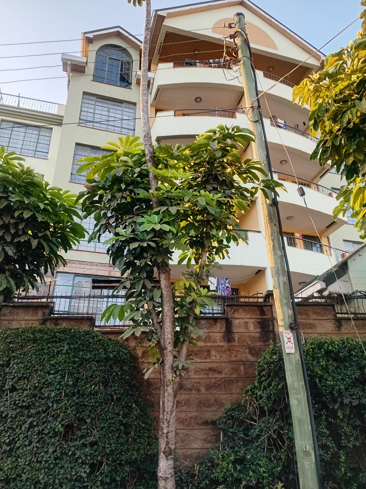 Multi-story residential building facade with balconies and landscaping