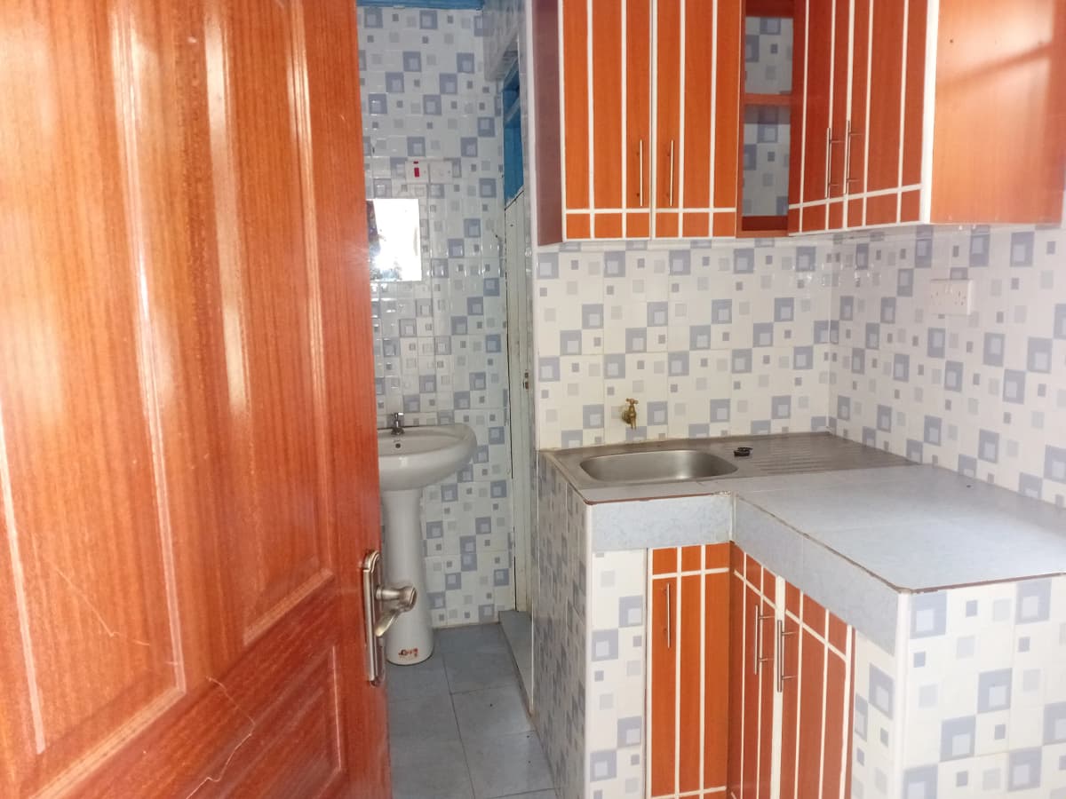 Compact bathroom with geometric tile walls and sink vanity