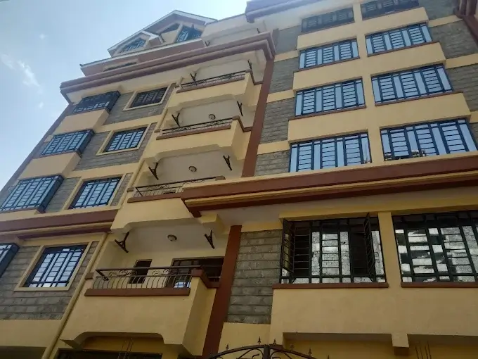 Multi-story residential building facade with yellow ochre walls