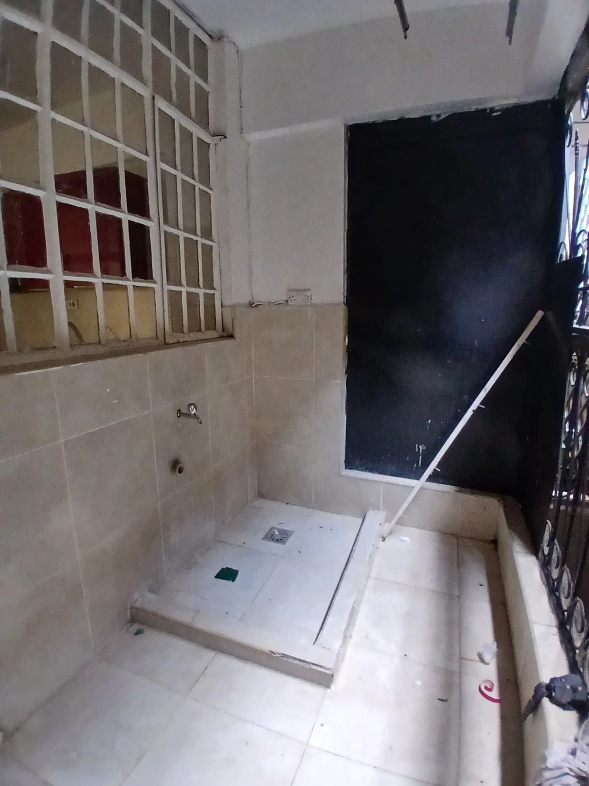 Bathroom with shower enclosure and tiled walls under renovation
