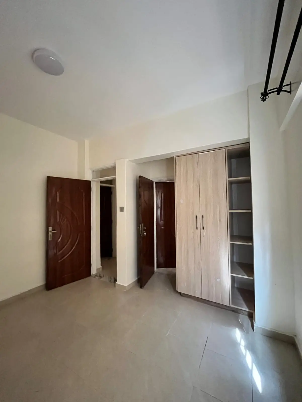 Spacious bedroom with built-in wardrobes and multiple doors