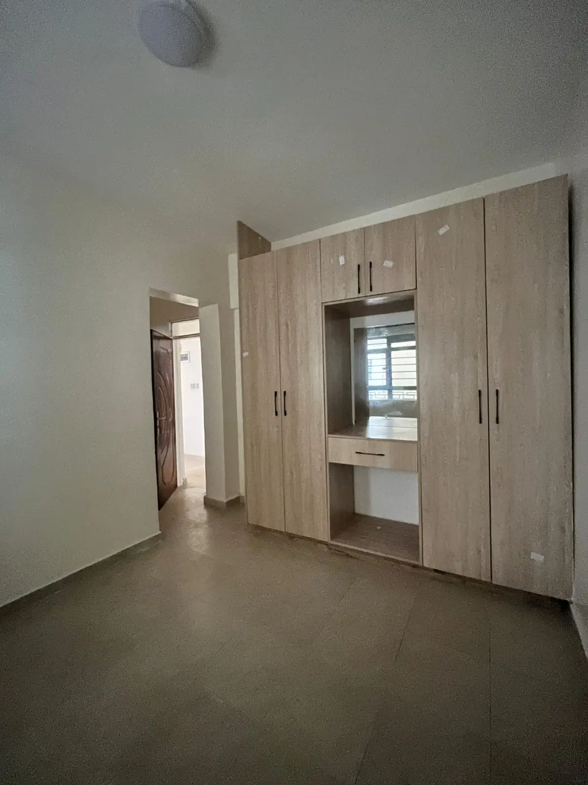 Bedroom with built-in wooden wardrobe and window