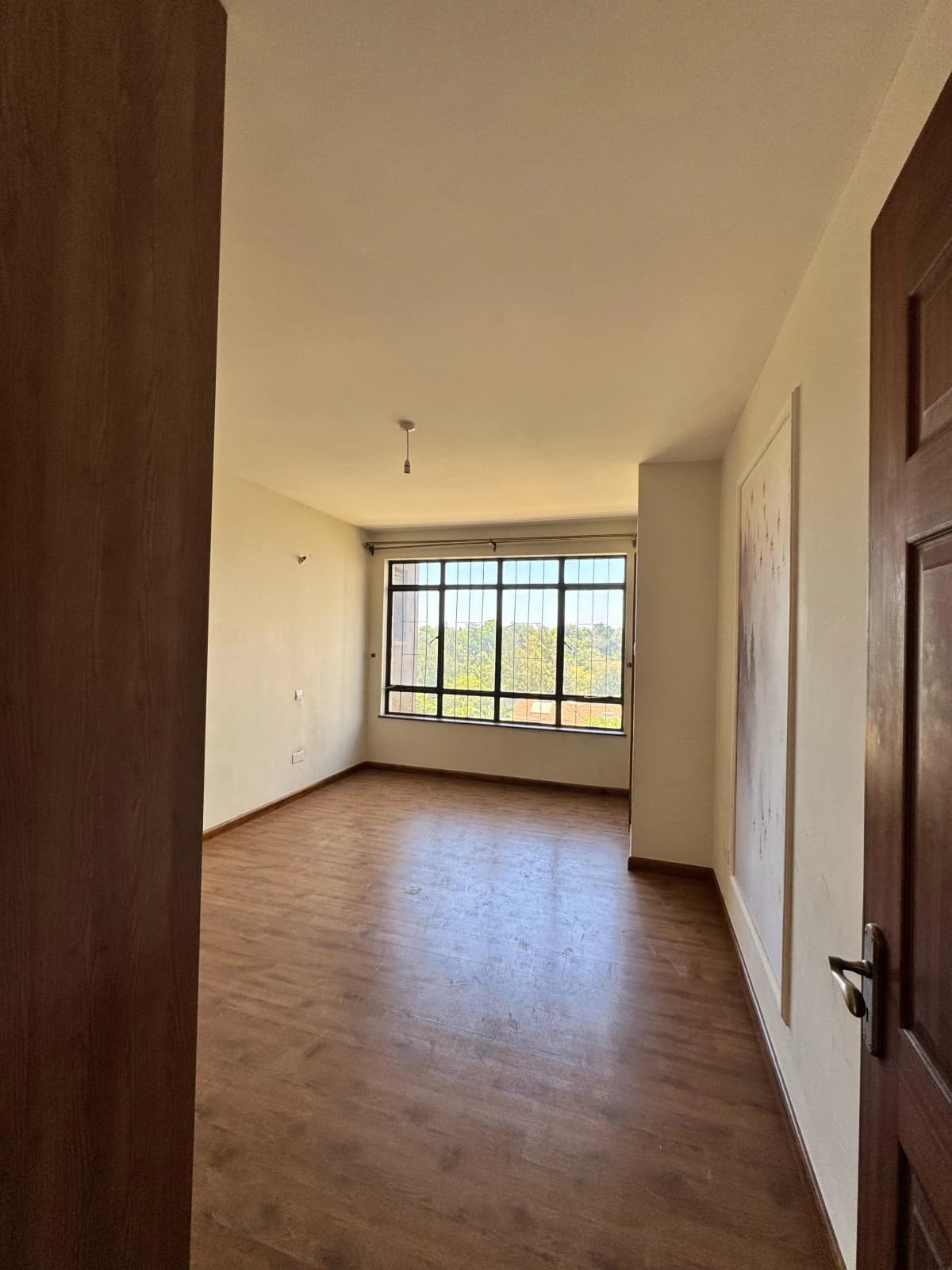 Spacious living room with wooden floors and large windows