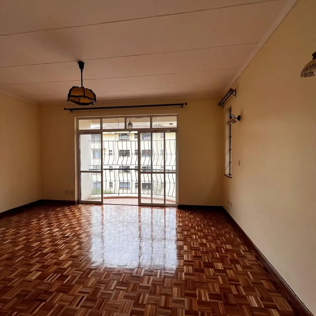 Spacious living room with parquet flooring and large glass doors