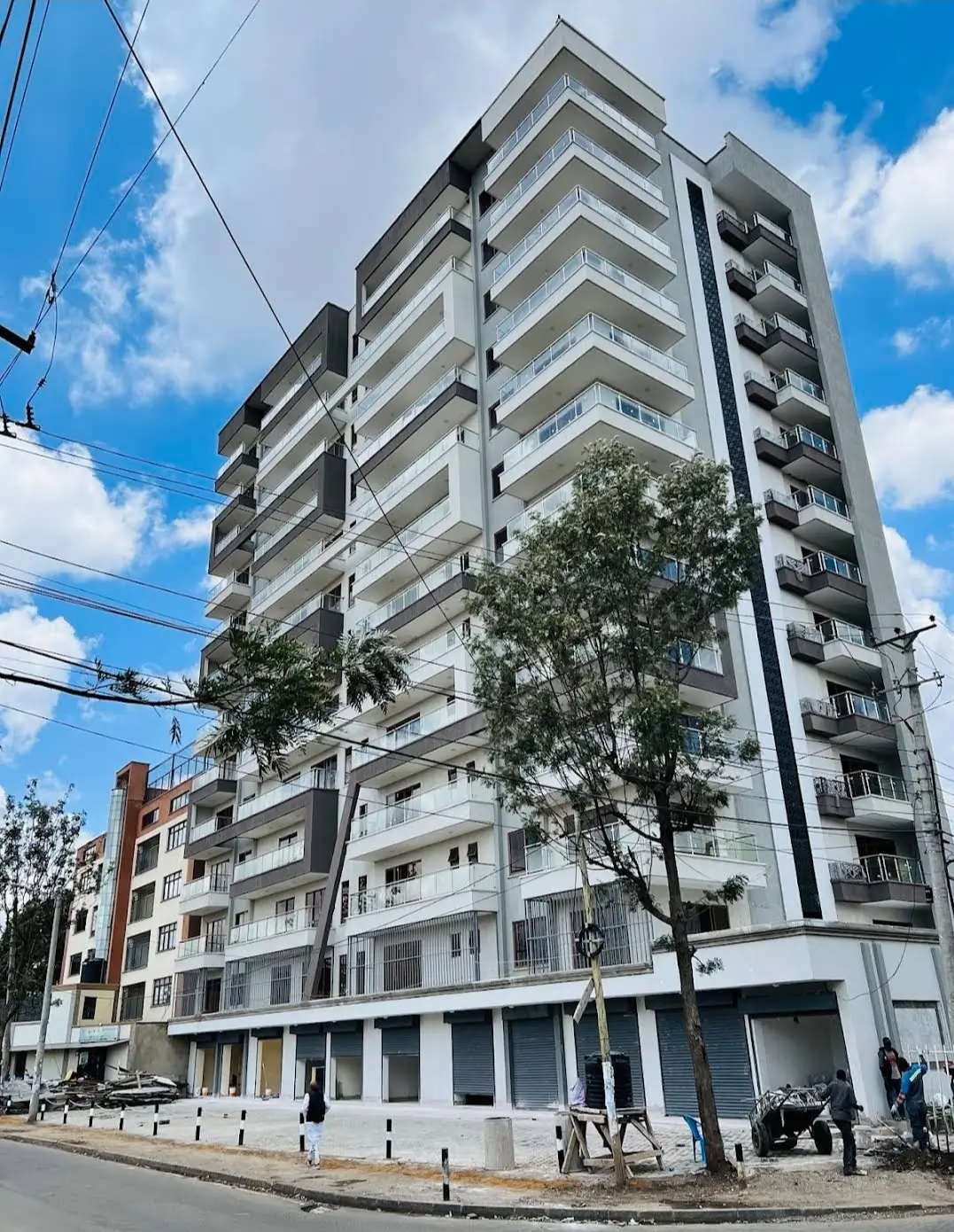 Modern multi-story residential building with balconies and street frontage