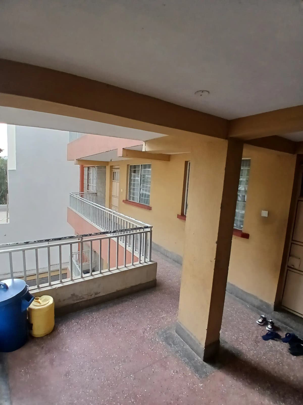 Covered balcony with metal railings overlooking compound