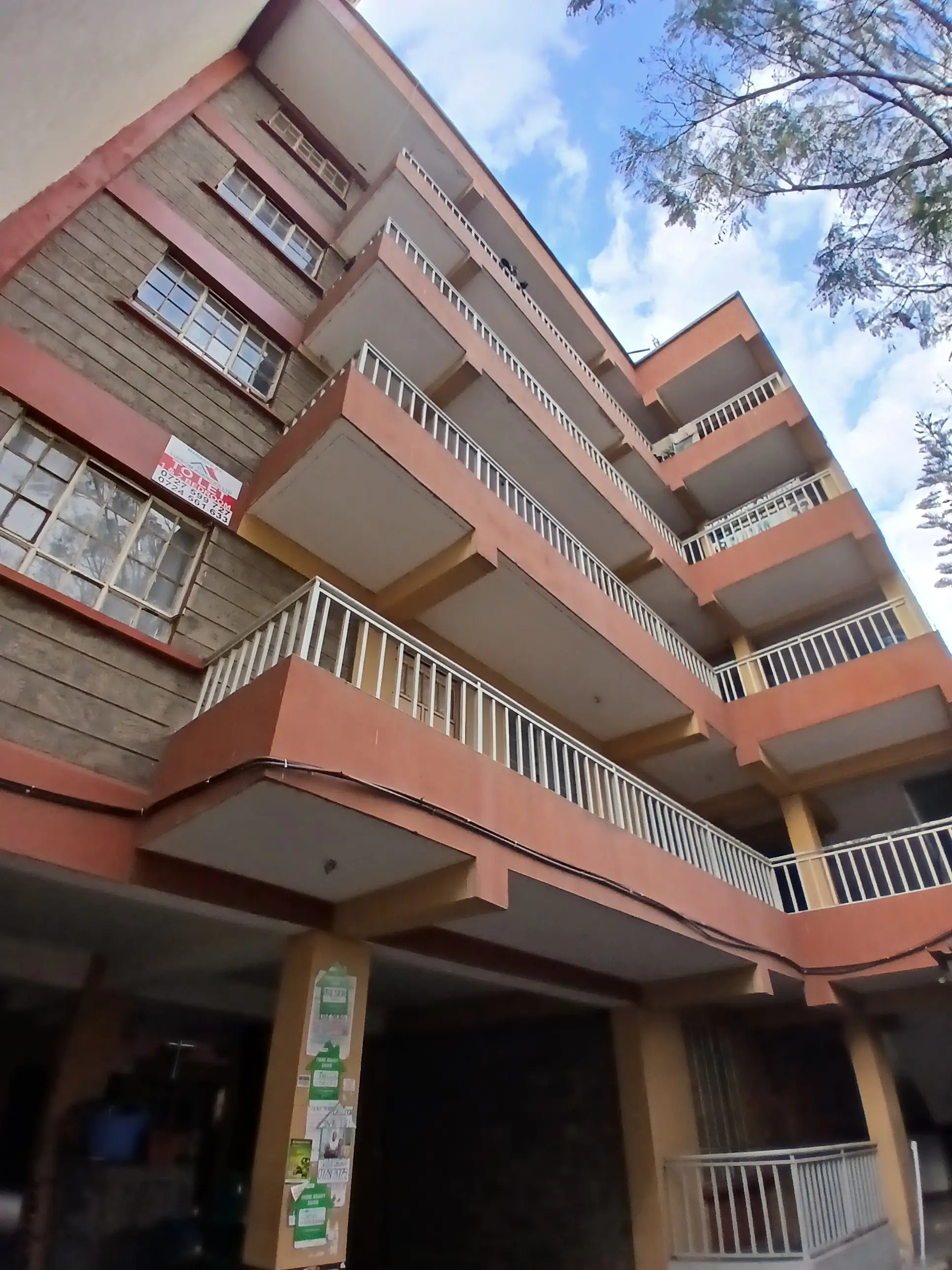 Multi-story residential building with terracotta facade and balconies