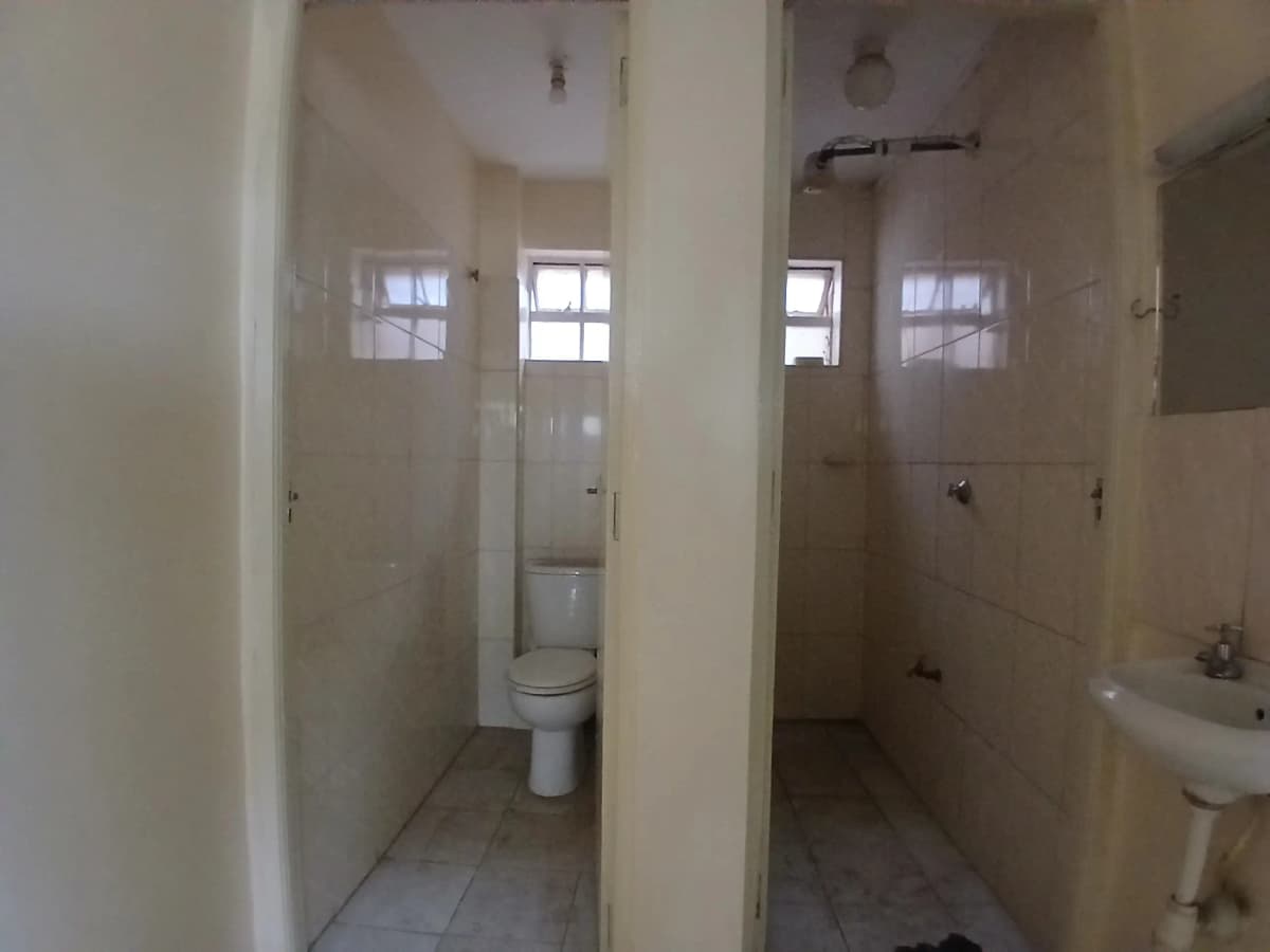 Multiple bathroom stalls with toilet and sink fixtures