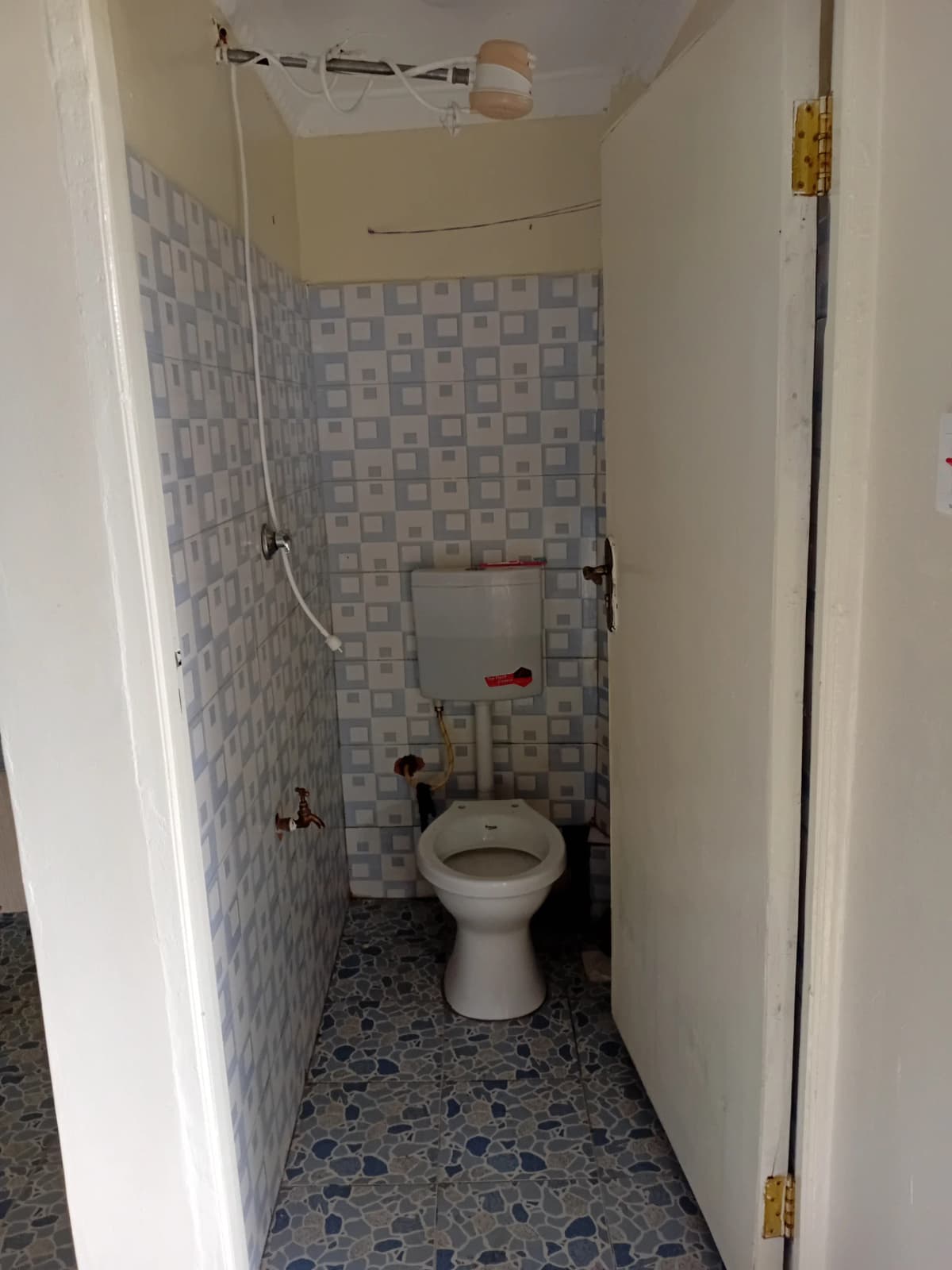 Compact toilet room with blue-grey tile walls and flooring