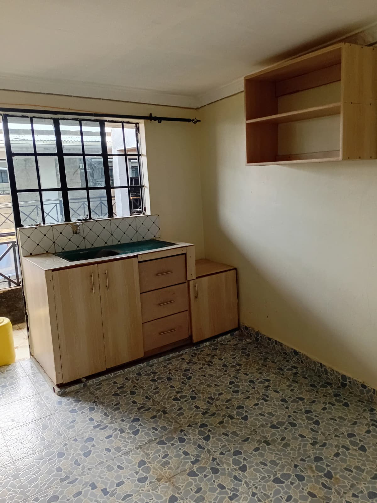 Compact kitchen with wooden cabinetry and window view