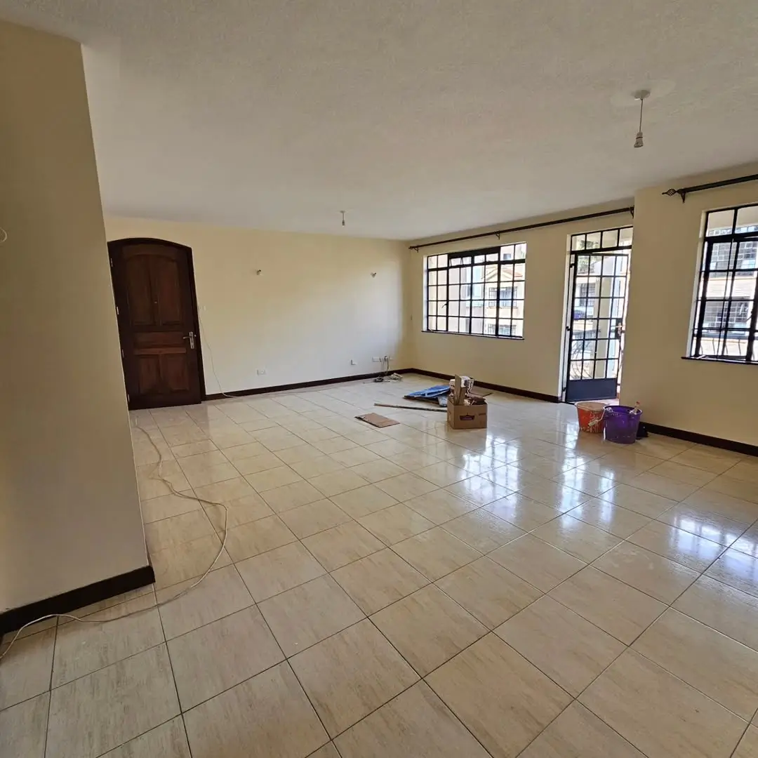 Spacious living room with polished tile flooring and natural light