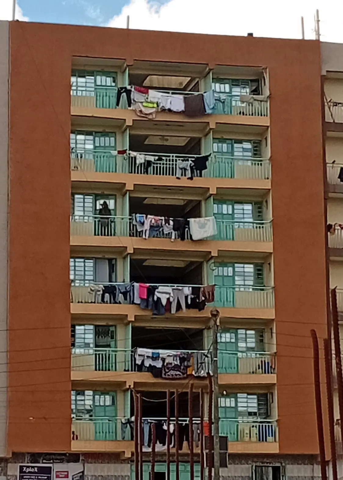 Multi-story residential building facade with green balconies