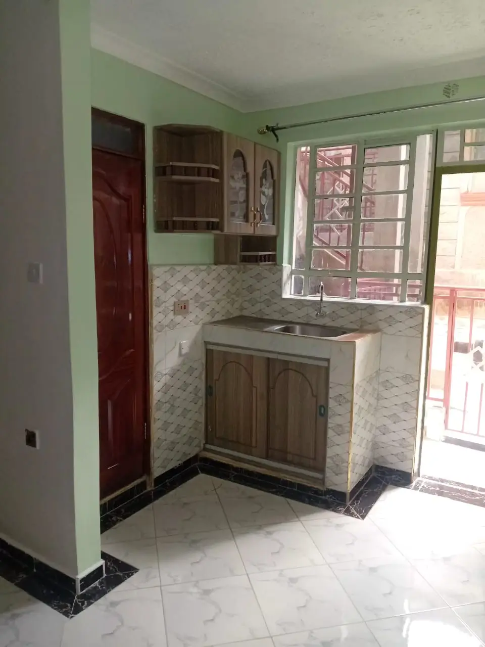 Compact kitchen with wooden cabinets and mosaic backsplash